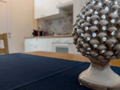 Pigna in ceramica siciliana sul tavolo da pranzo con la cucina sullo sfondo