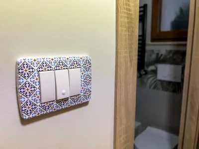 Placca degli interruttori decorata in stile maiolica con vista sul bagno